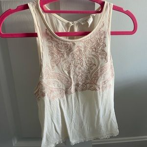 White tank top with pink details and lace trim on the bottom